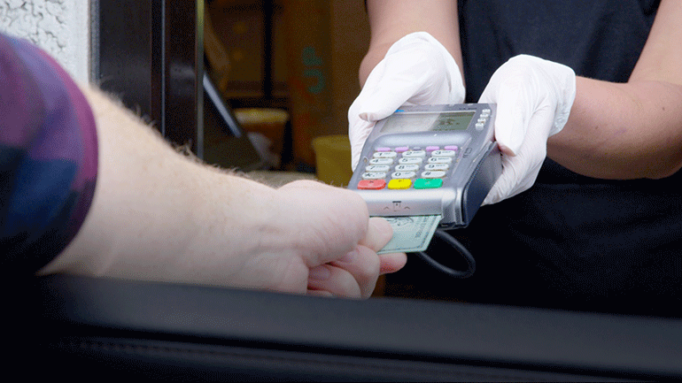 A Taco Bell drive-thru customer does contactless credit card payment