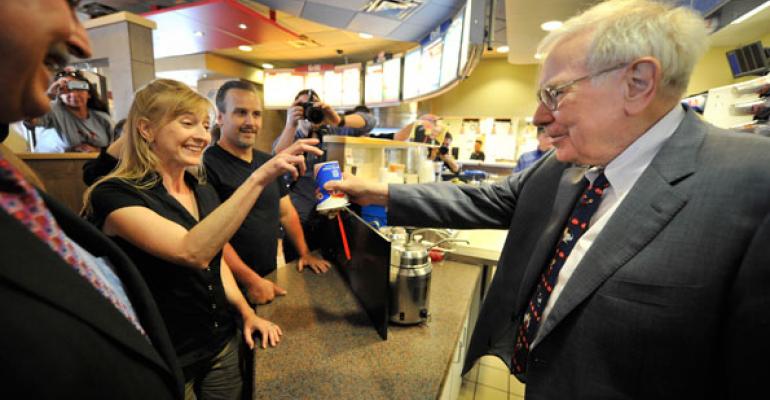 Famous investor Warren Buffet right serving the first Smores Blizzard at a Dairy Queen location in Omaha Neb