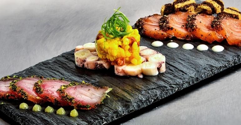 From left Herbcured kampachi with cilantrolime crema octopus torchon with pickled corn and chorizo and salmon pastrami with Thousand Island aoli and toasted rye bread
