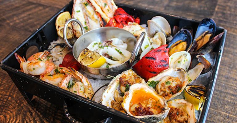 Oysters get grilled torched and served in a special smoke box at Del Campo in Washington DC