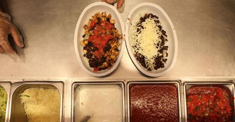 Cooks prepare food at Chipotle Mexican Grill