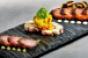 From left Herbcured kampachi with cilantrolime crema octopus torchon with pickled corn and chorizo and salmon pastrami with Thousand Island aoli and toasted rye bread
