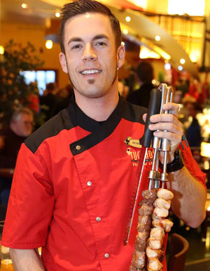 A Tucanos server presents skewers of meat